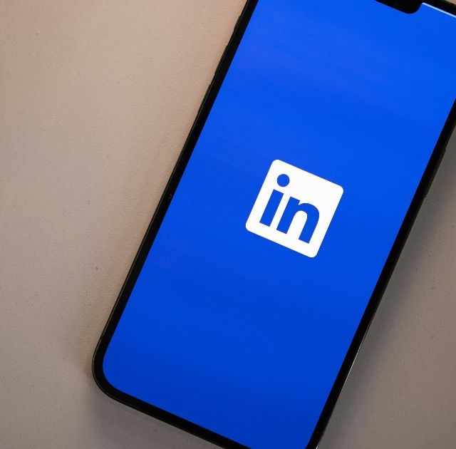 Smartphone som visar LinkedIn-applikationens blå skärm, viktig för webbplatsdesign och professionella nätverk som ZORC